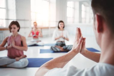 Yetişkin kadın uygun ve pratik yoga teşkil etmektedir fitness sınıfı dostum. Uygun Grup yapıyor sağlıklı güçlü insan egzersizleri beyaz spor salonunda. Sağlık ve yaşam tarzı