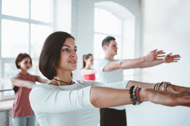 Portre güçlü uygun kadın Eğitim Yoga fitness mat ile birlikte grup arka plan üzerinde insan teşkil etmektedir. Healthe bakım ve lifestyl