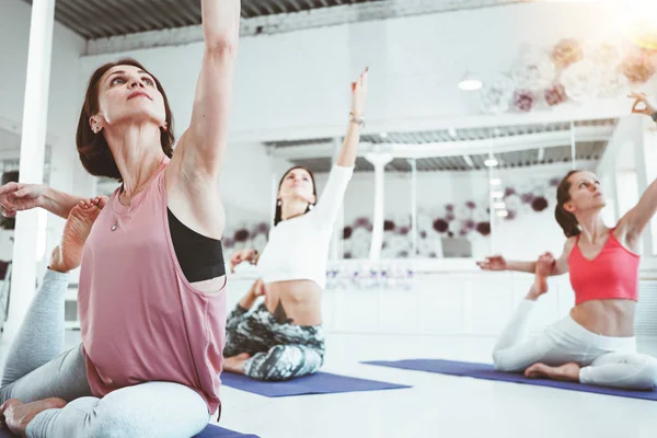 Yoga exerciese fitness mat beyaz spor sınıf pratik güçlü sağlıklı kadın üzerinde yakından görmek. Yetişkin kadın yapıyor erken sabah kapalı arka plan insanlar üzerinde uzanan uygun
