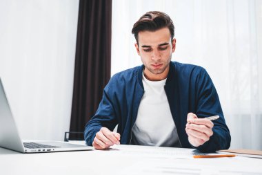 Tablo kullanmak laptop ve ofis alanı Not Defteri'nde oturan işadamı portresi. Genç erkek öğrenci hazırlama projesi