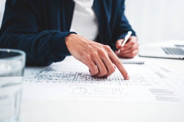 Dizüstü bilgisayar ve yazıcı blueprint modern ofiste kullanan birlikte çalışan adam. Çalışma alanı üzerinde çalışan grafik tasarımcı adam