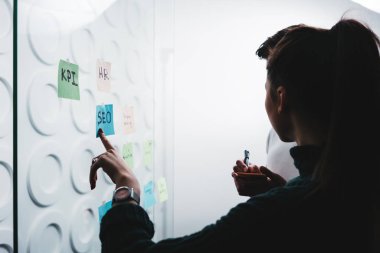 Yaratıcı çözüm duran cam duvarın arkasında yapışkan notlar ofis ile paylaşımı proje üzerinde birlikte fikirleri tartışmak insanlar coworking siluet. İki proje yöneticileri Toplantısı