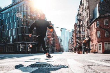 New York sokaklarında asfalt üzerinde çalışan kentsel Erkek atlet. Hızlı adam atlet spor giyim için maraton hazırlanıyor giyiyor