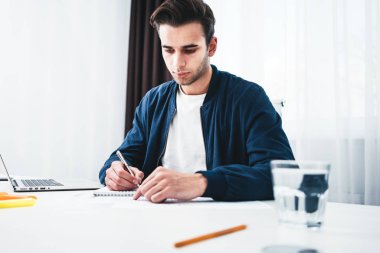 Tablo kullanmak laptop ve ofis alanı Not Defteri'nde oturan işadamı portresi. Genç erkek öğrenci hazırlama projesi