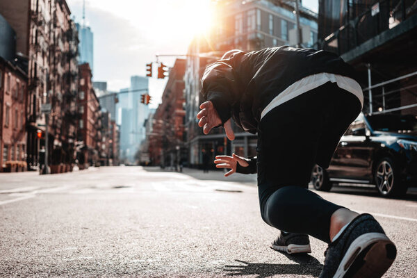 Strong male athlete prepearing for competition and marathone on urban street. Young runner in strat pose on New York streets