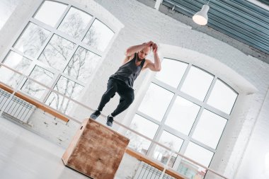 Bir kutu yapan güçlü erkek egzersiz spor salonunda egzersiz atlamak. Crossfit tatbikatların kutusunu kullanarak erkek atlet