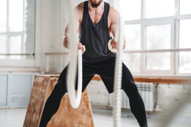 Crossfit hall adlı savaş halatlar ile çalışma dışarı adam uygun. Erkek atlet ile eğitim fitness kulübünde ipleri