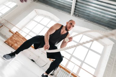 Savaş kullanarak uygun adam atlet hafif spor salonunda egzersiz için ipleri. Spor salonunda egzersiz için eğitim halatlar kullanarak güçlü fitness sporcu
