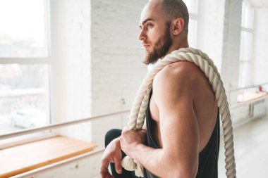 Yakın çekim portre güçlü adam spor salonu çapraz crossfit halatlar içinde uyum. Kas atlet savaş tutarak salonu çapraz içinde omuzlarında ipleri