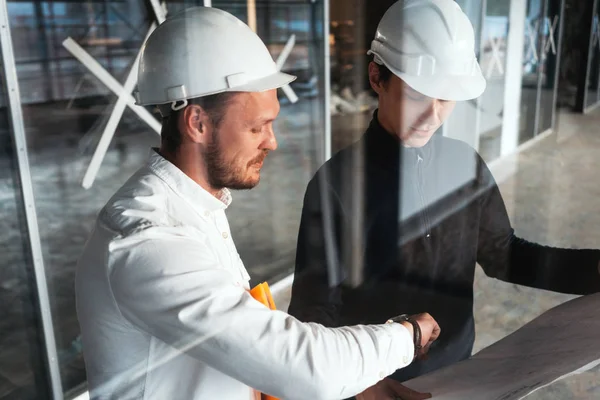Two Building Engineers Wearing Safety Hard Hat Discussing Blueprint Construction — Stock Photo, Image