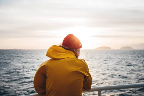 모자와 비옷을 여행자가 폭풍과 안개가 스카이 라인에 바다를 바라보고 있습니다 — 스톡 사진