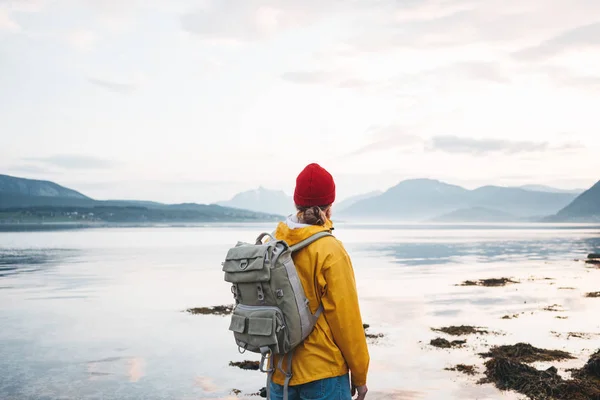 배낭과 노란색 비옷을 피요르드를 바라보는 힙스터 여행자 스칸디나비아 풍경에서 여행하는 — 스톡 사진