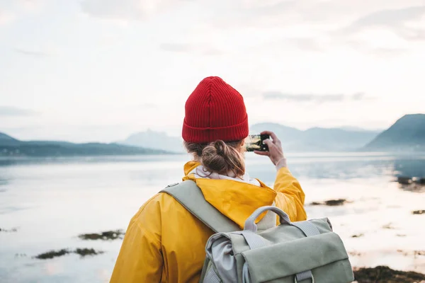 비옷과 배낭을 여행자가 북유럽 풍경의 스마트 폰에서 사진을 찍습니다 스마트 — 스톡 사진
