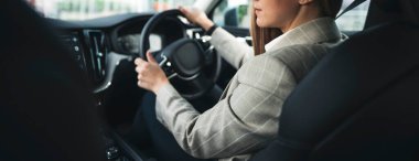 Modern araba kullanan bir iş kadını. Direksiyon başında oturan genç iş kadını arabayla seyahat ediyor. Geniş açı