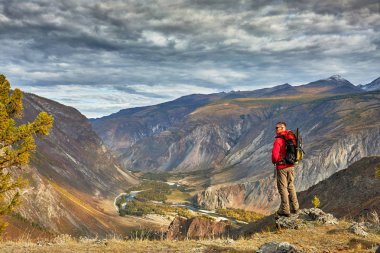 Genç adam Traveler rahatlatıcı rocky Dağları ile açık arka plan sonbaharda tatiller ve yaşam tarzı