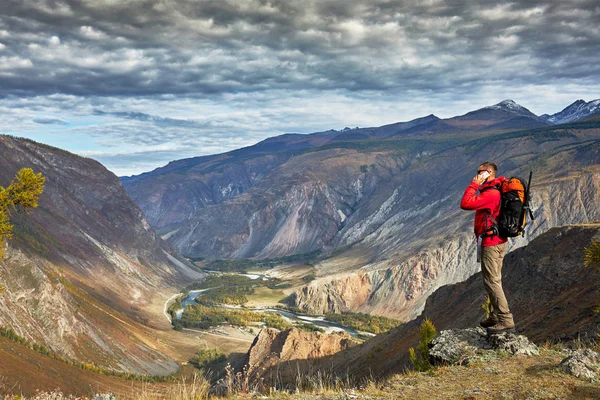 Ung Man Traveler koppla av utomhus med klippiga bergen på bakgrunden hösten semester och livsstil — Stockfoto
