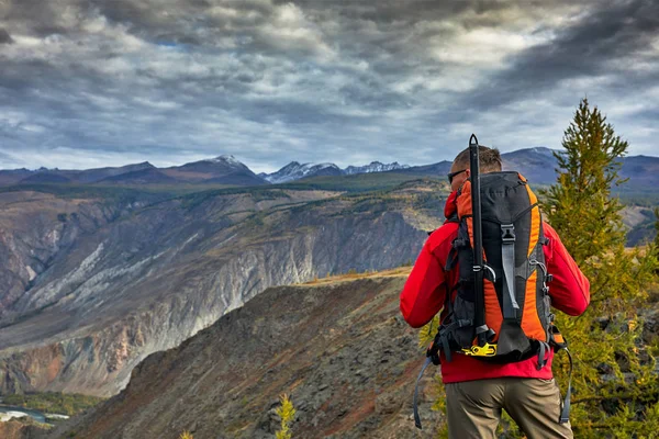 Ung Man Traveler koppla av utomhus med klippiga bergen på bakgrunden hösten semester och livsstil — Stockfoto