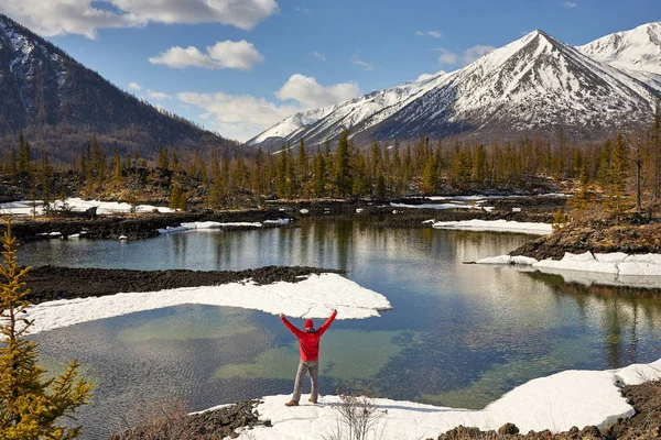 Feliz turista en la orilla de un lago de montaña. Paisaje invierno . — Foto de Stock