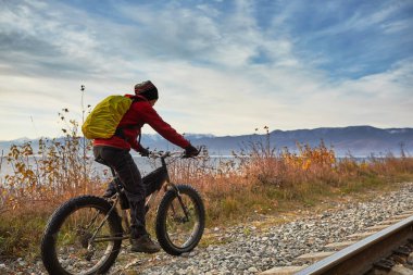 Turist Baykal Gölü Kıyı boyunca geniş tekerlekli bisiklet sürmek.