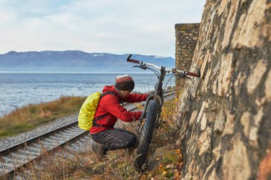 Turist Baykal Gölü Kıyı boyunca geniş tekerlekli bisiklet sürmek.