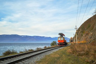 Bir tramvay araba Baykal Gölü demiryoluna yayılıyor. Güzel sonbahar manzara.