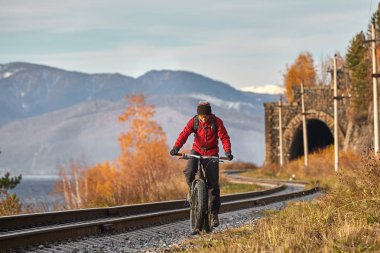 Turist Baykal Gölü Kıyı boyunca geniş tekerlekli bisiklet sürmek.