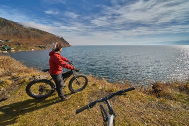 Turist Baykal Gölü Kıyı boyunca geniş tekerlekli bisiklet sürmek.