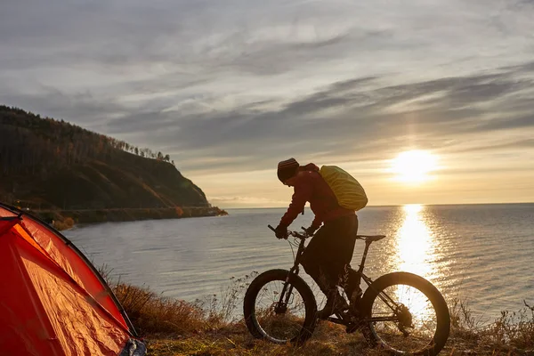 Turist rider en cykel med breda hjul längs den sjön Baikal. — Stockfoto