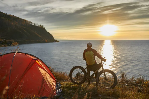 Turist rider en cykel med breda hjul längs den sjön Baikal. — Stockfoto