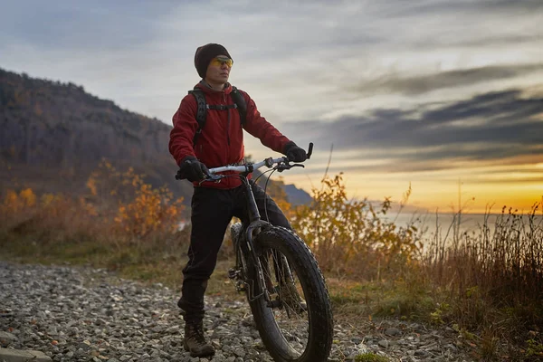 Tourist rides a bike with wide wheels along the shore of Lake Baikal. — Stock Photo, Image