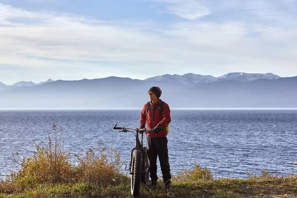 Turist rider en cykel med breda hjul längs den sjön Baikal. — Stockfoto