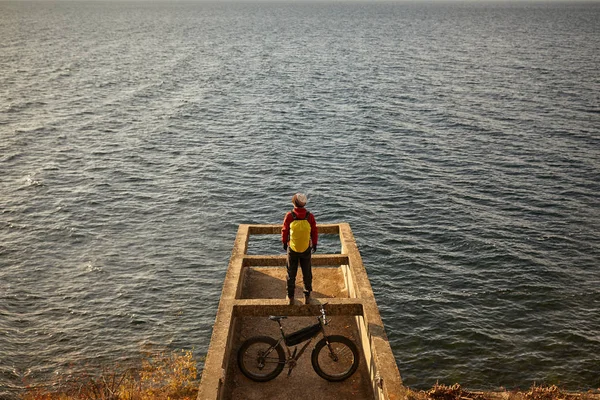 Tourist rides a bike with wide wheels along the shore of Lake Baikal. — Stock Photo, Image