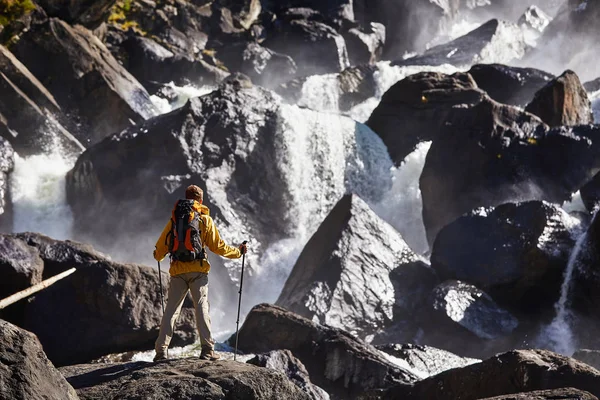 Lycklig man med ryggsäck njuter av fantastiska vattenfall resor livsstil och framgång konceptet semester i den vilda naturen — Stockfoto