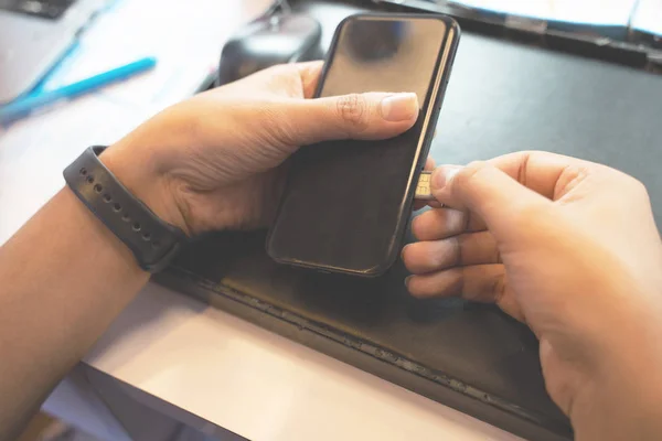 Employees are putting nano SIM cards in the store for customers to buy,Man\'s hand.