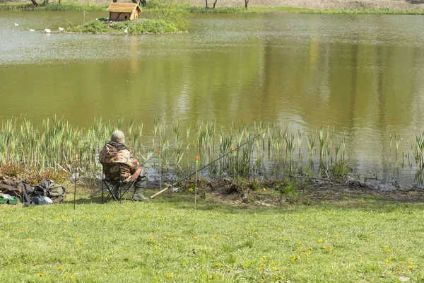 gölde oturan olta çubukları ile balıkçı