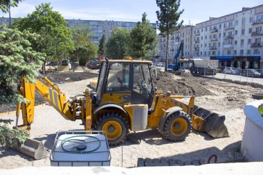 İnşaat alanında duran sarı kazıcı