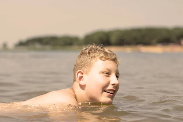 the boy is swimming on the lake