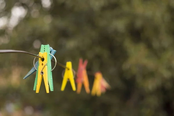 Bulanık Arka Plan Ile Bir Üzerinde Asılı Renkli Clothespins — Stok fotoğraf