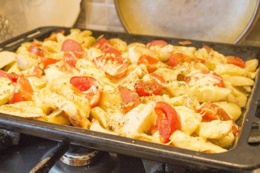 bir fırın tepsisine kırmızı domates ile kızarmış patates