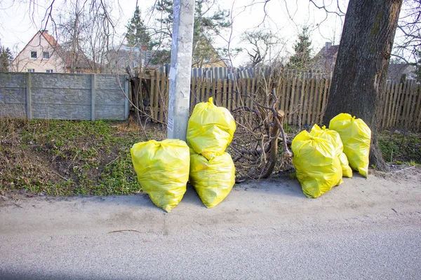 garbage bags stand near the road, pollution of nature