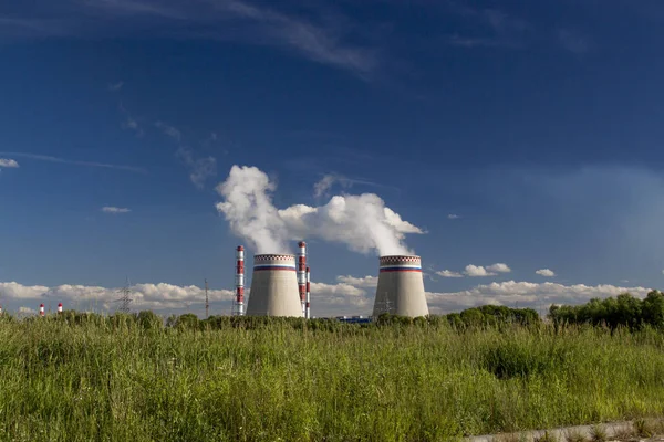 yeşil çim arka planda enerji santrali boruları, ekoloji