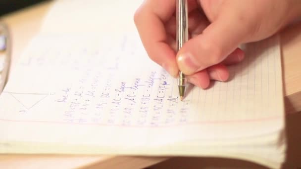 Un adolescente con un primer plano escrito en un cuaderno — Vídeo de stock