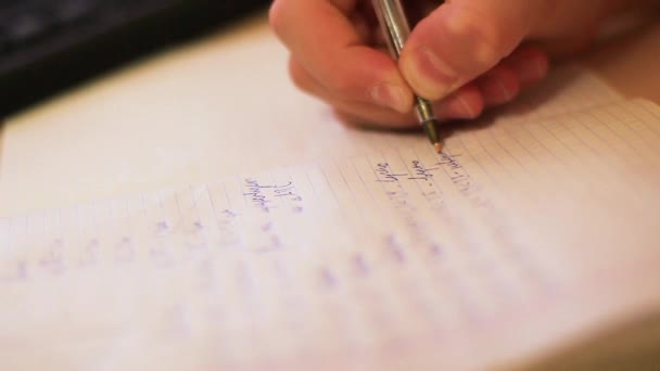 A teenager with close-up writing in a notebook — Stock Video