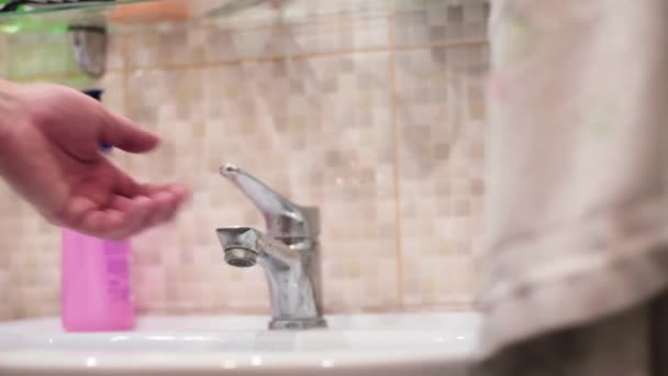 Main d'homme ouvre le robinet avec de l'eau dans la salle de bain — Video
