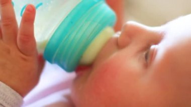 küçük bebek bir meme ile bir şişe süt içecekler