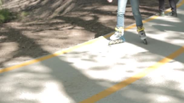 Tiener meisje schaatsen op rolschaatsen. benen close-up — Stockvideo