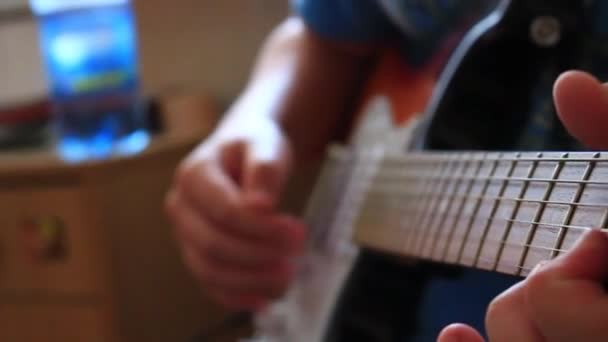 The boy 's hands playing the guitar closeup — стоковое видео