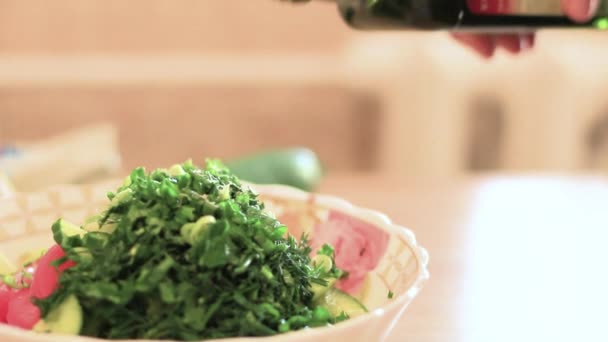 Ženská ruka blízkná pro lití olivového oleje do salátu — Stock video
