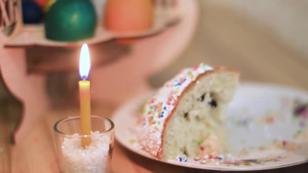 Пасхальная свеча горит на столе рядом с пасхальным тортом — стоковое видео