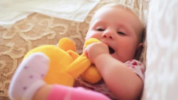 Menina recém-nascida brincando com um brinquedo na forma de uma banana — Vídeo de Stock